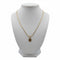 Gold necklace with a spiral pendant on a marble surface