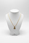 Gold hairpin with decorative end on a marble surface