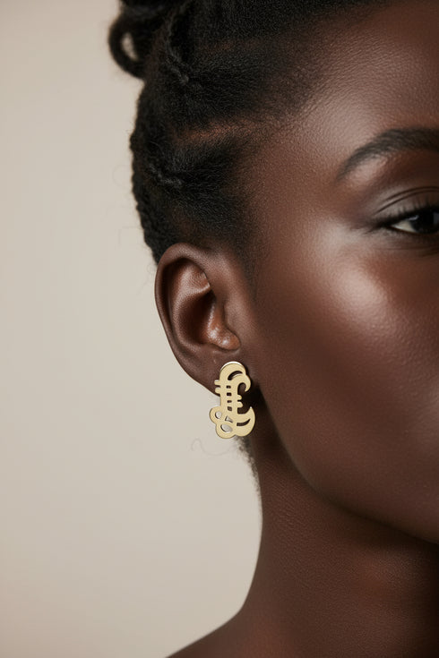 Pair of black shoe-shaped earrings on a marble surface