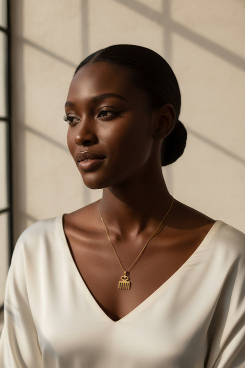 Gold necklace with a key-shaped pendant on a marble surface