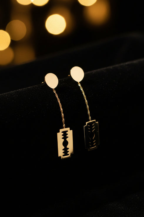 Gold earrings on a marble surface