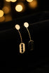 Gold earrings on a marble surface
