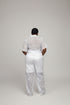 A person shown from behind wearing a white lace outfit with a black geometric patterned top and white pants, standing indoors in front of a black slatted wall. Large overlaid text at the top reads 'Price - N40,000 WhatsApp +2347030500842', and social-style interface icons and a phone preview are visible around the frame.