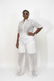 A model wearing a white two-piece outfit with a short-sleeve button-up shirt and matching wide-leg pants, both featuring a textured crochet lace pattern. She is posing against a plain white studio background.