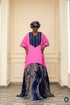 A woman modeling a bright pink and navy blue top with a long patterned skirt, shown in a social media post with promotional text overlay.