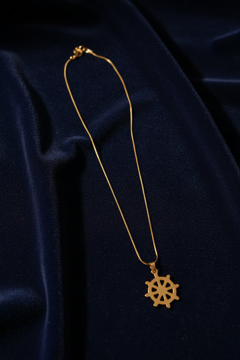 Gold necklace with a pendant on a white mannequin bust against a white background