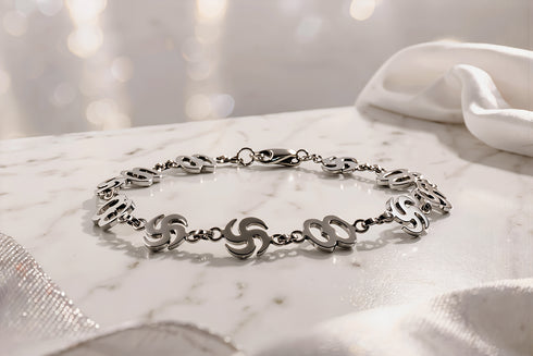 Silver bracelet on a marble surface with a soft, blurred background