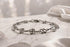Silver bracelet on a marble surface with a soft, blurred background