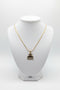 Gold-colored necklace with decorative end on a marble background