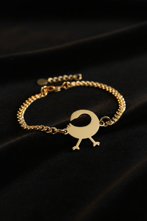 Gold bracelet with a unique clasp on a marble background