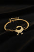 Gold bracelet with a unique clasp on a marble background