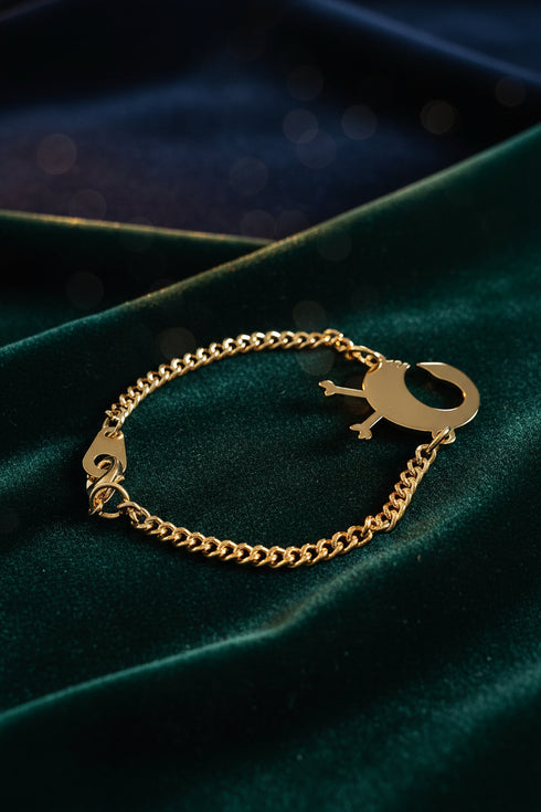 Gold chain bracelet with a unique clasp on a marble background