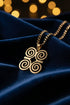 Gold necklace with a decorative clasp on a marble surface