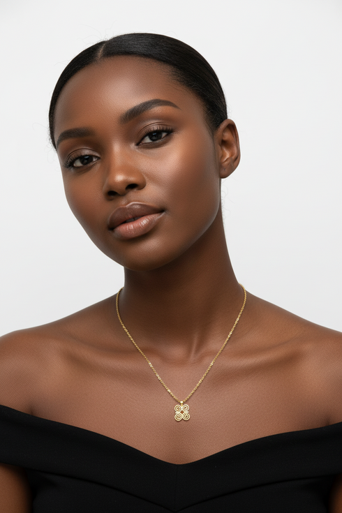 Gold necklace with a decorative clasp on a white background