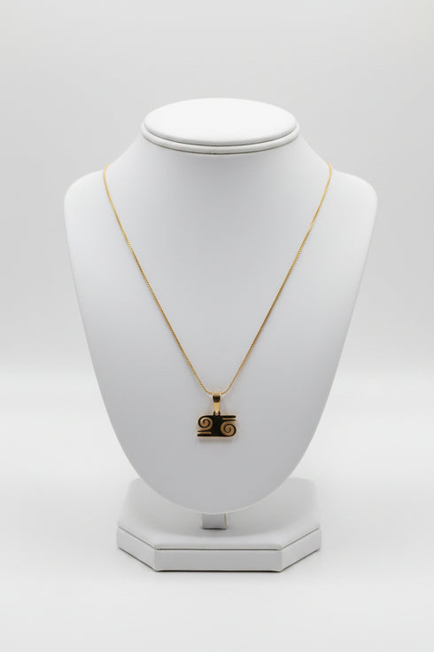 Gold necklace with a pendant on a white mannequin bust against a white background