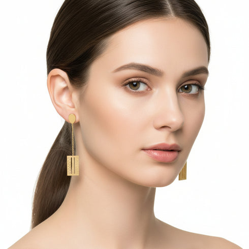 Gold earrings on a marble surface