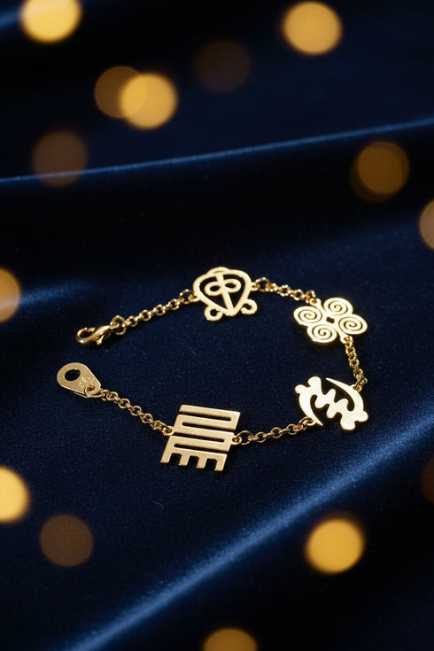 Gold chain bracelet with decorative elements on a marble surface