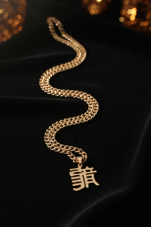 Gold chain necklace with a pendant on a marble surface