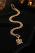 Gold chain necklace with a pendant on a marble surface