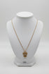 Gold necklace with a heart-shaped pendant on a white mannequin bust.