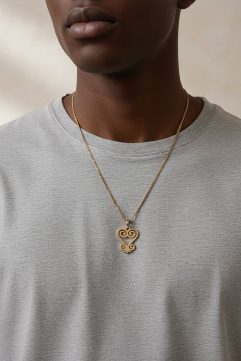 Gold necklace with an ornate clasp on a marble surface