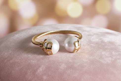 Gold ring with two pearls on a pink velvet surface