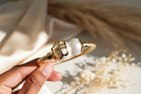 Decorative object with pearl and gold elements on a marble background
