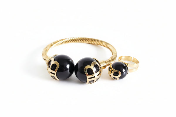 Gold and black beaded earring on a marble background