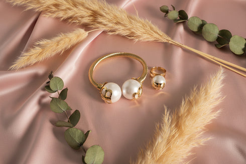Gold and pearl earring on a marble surface