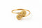 Gold bracelet with textured spherical ends on a marble surface