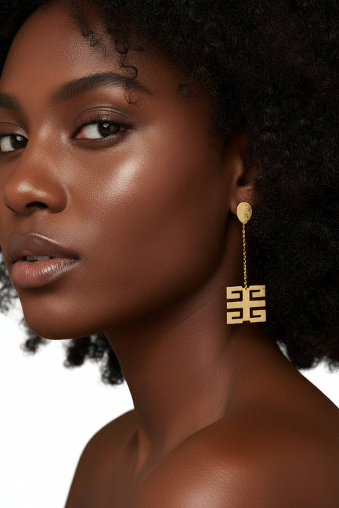 Gold earrings on a marble surface