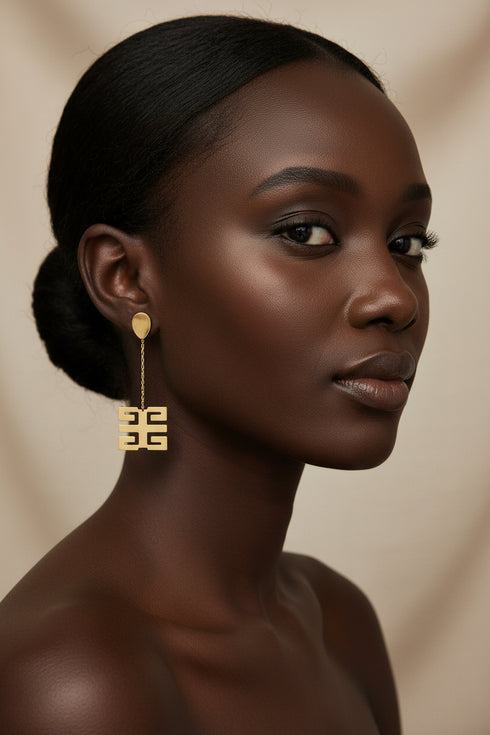 Pair of gold earrings on a marble surface