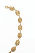 Gold bracelet with floral designs on a marble surface