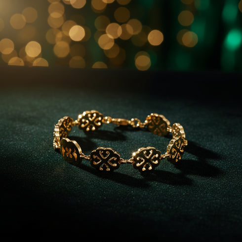 Gold bracelet with floral designs on a marble surface