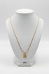 Gold necklace with a decorative clasp on a marble surface