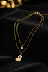 Gold necklace with a heart-shaped pendant on a marble surface