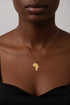 Gold necklace with a cross pendant on a marble surface
