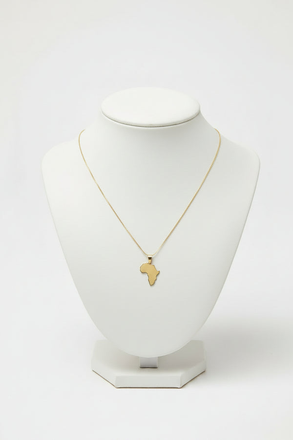 Gold necklace with a African map pendant on a marble surface