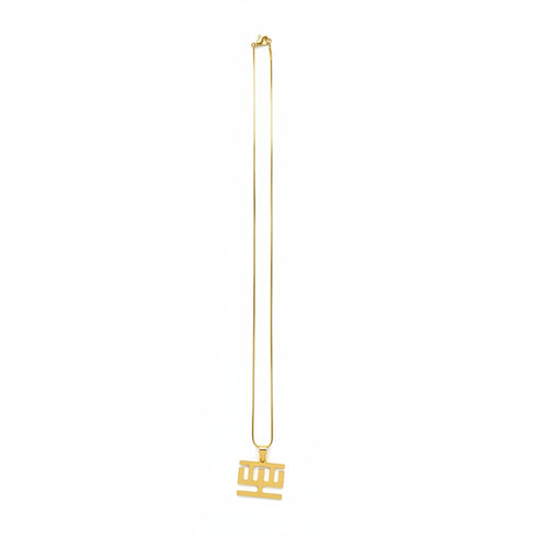 Gold necklace with a black clasp on a marble surface