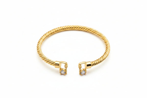 Gold bracelet with diamond accents on a marble surface