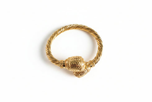 Gold ring with a textured design on a white background