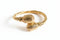 Gold bracelet with textured design on a white background