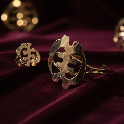 Gold jewelry piece on a purple fabric background