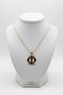 Gold necklace with a unique pendant on a marble surface