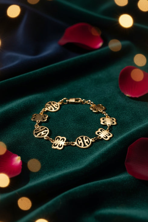 Gold bracelet with floral and circular designs on a marble surface
