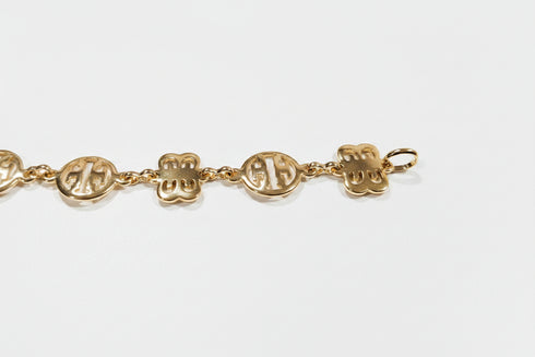 Gold bracelet with engraved symbols on a marble surface
