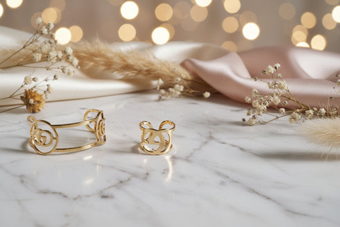 Two gold rings on a marble surface with blurred lights in the background