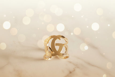 Gold ring with a logo on a light background