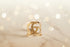 Gold ring with a logo on a light background