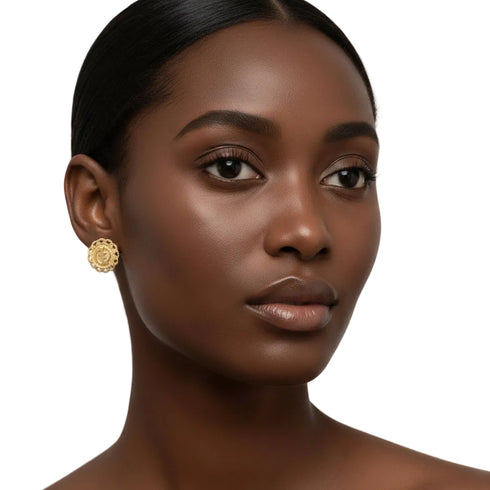 Close-up of a woman wearing a gold earring against a beige background